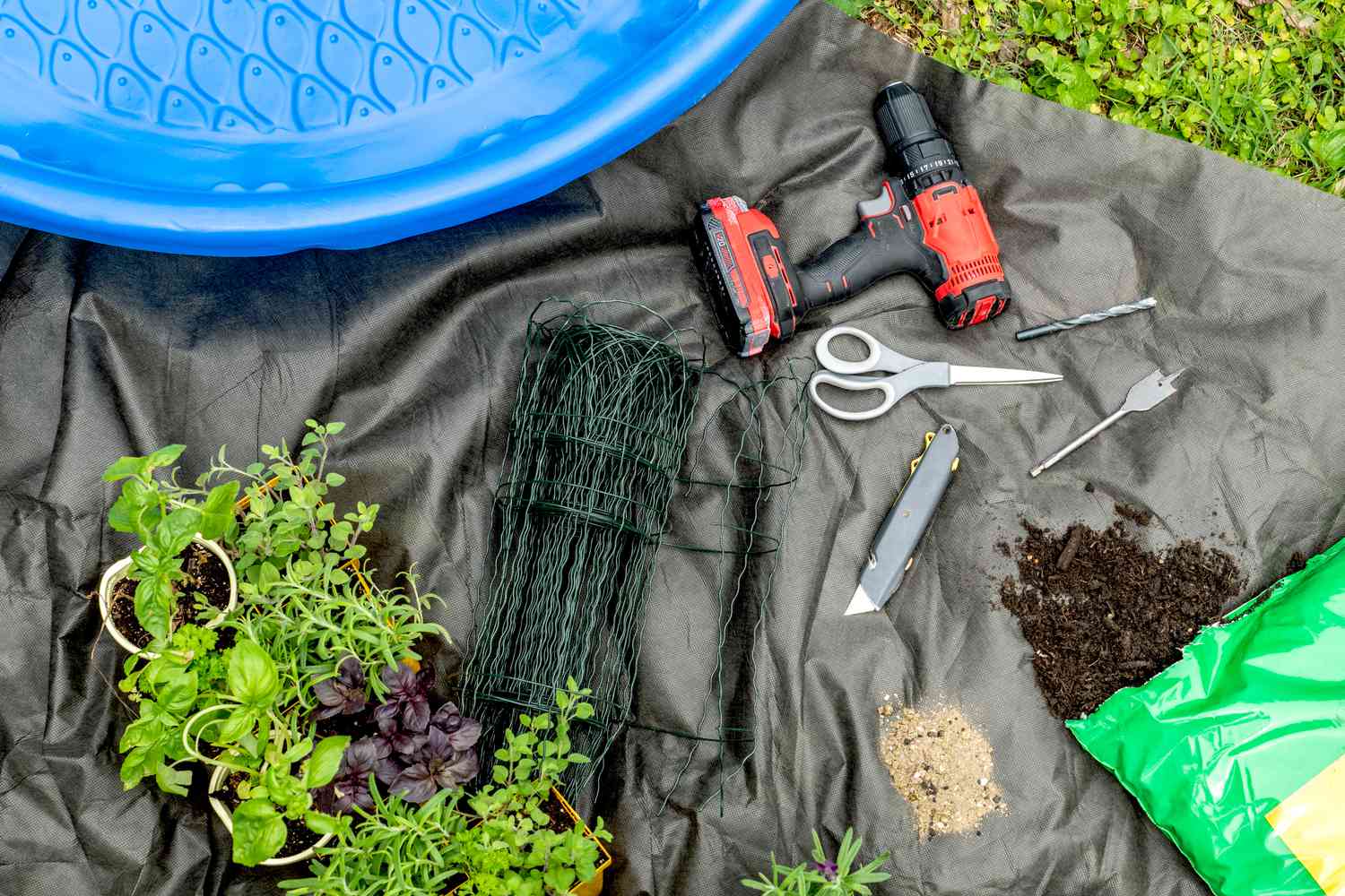 Materialien und Werkzeuge zum Anlegen eines Gartens in einem Kinderbecken