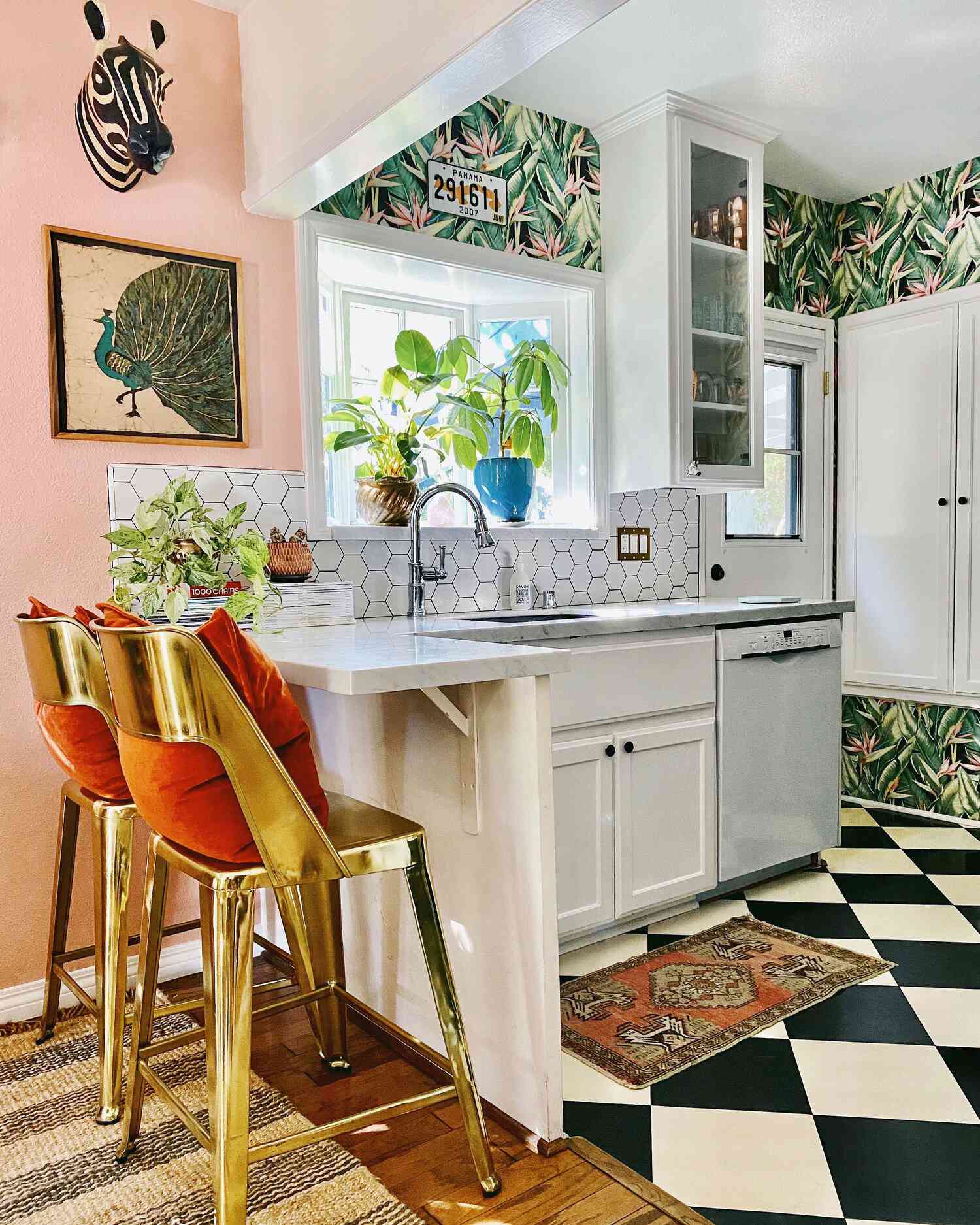 cozinha pequena eclética com papel de parede com padrão de folhas, backsplash de azulejos hexagonais, piso quadriculado preto e branco.