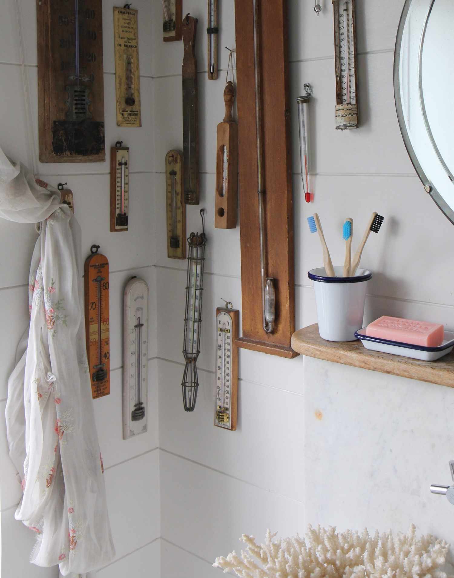 Salle de bain avec thermomètres vintage accrochés au mur.