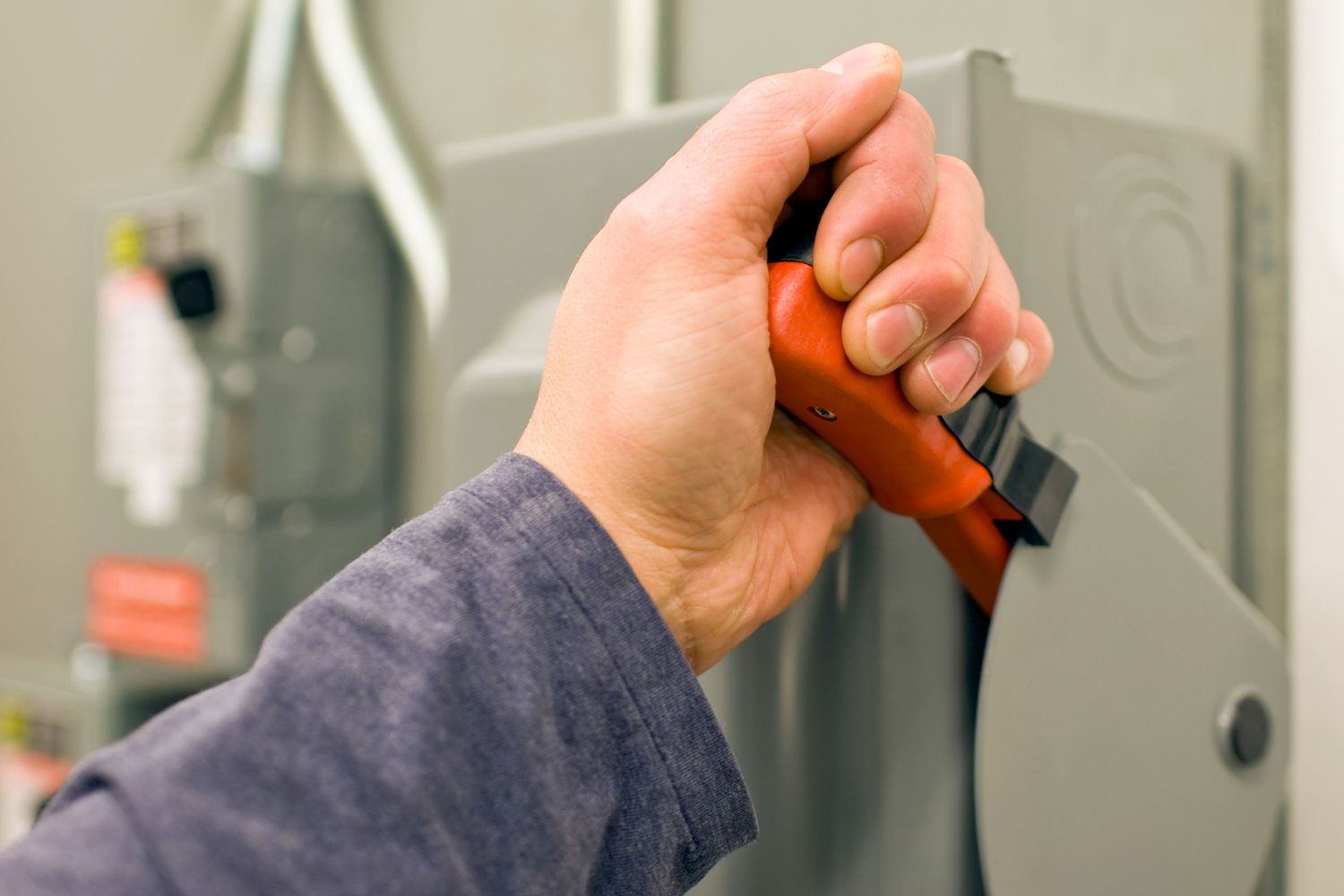 Ein elektrischer Trennschalter, der von einer Hand gezogen wird