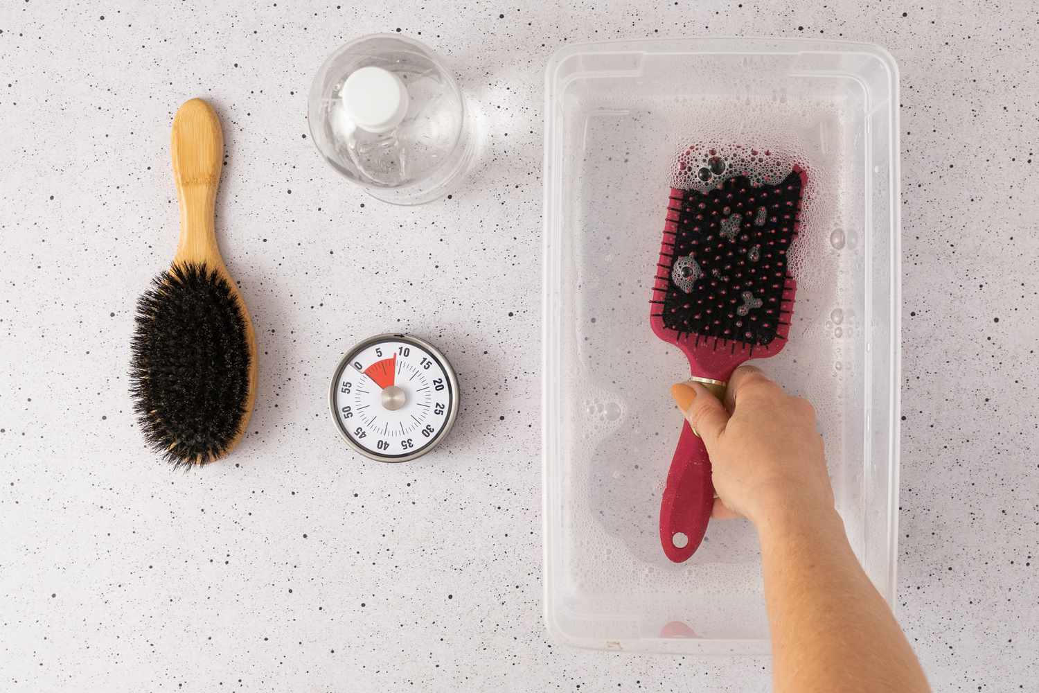 Remojar un cepillo de pelo en una solución limpiadora