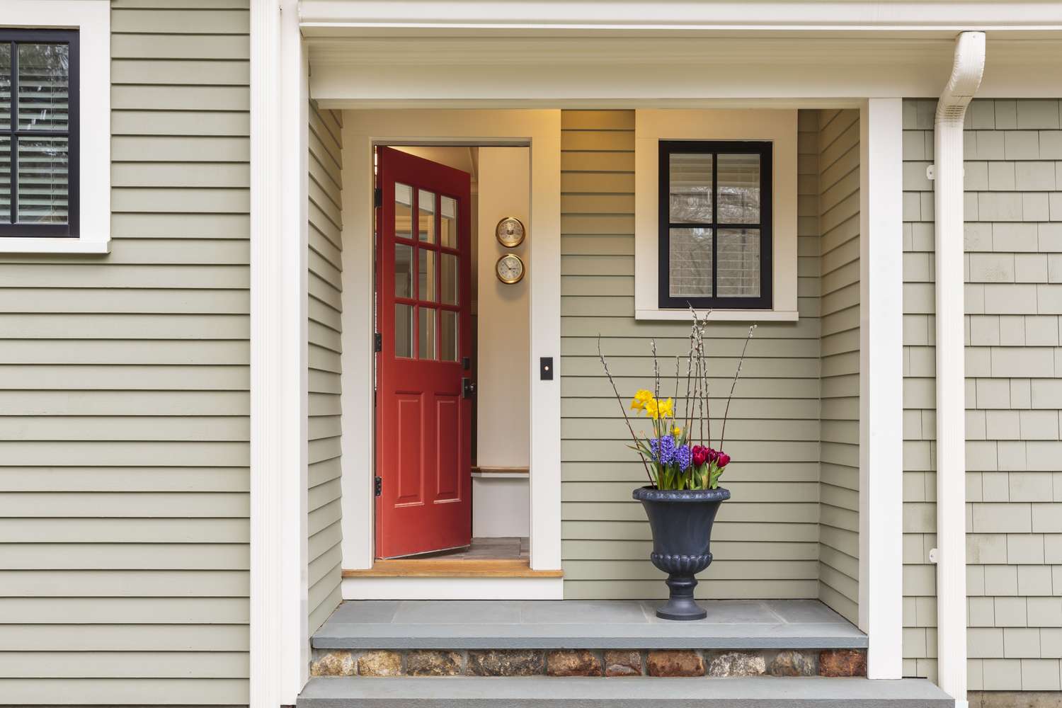 Einladender Eingang zu einem Haus mit roter Tür und Blumen