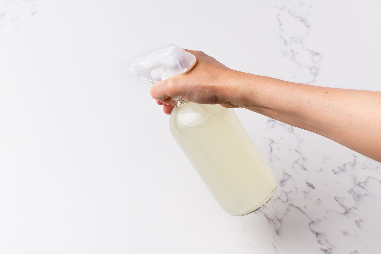 Zitronenkalkspray auf weißem Marmor zur Reinigung aufgetragen