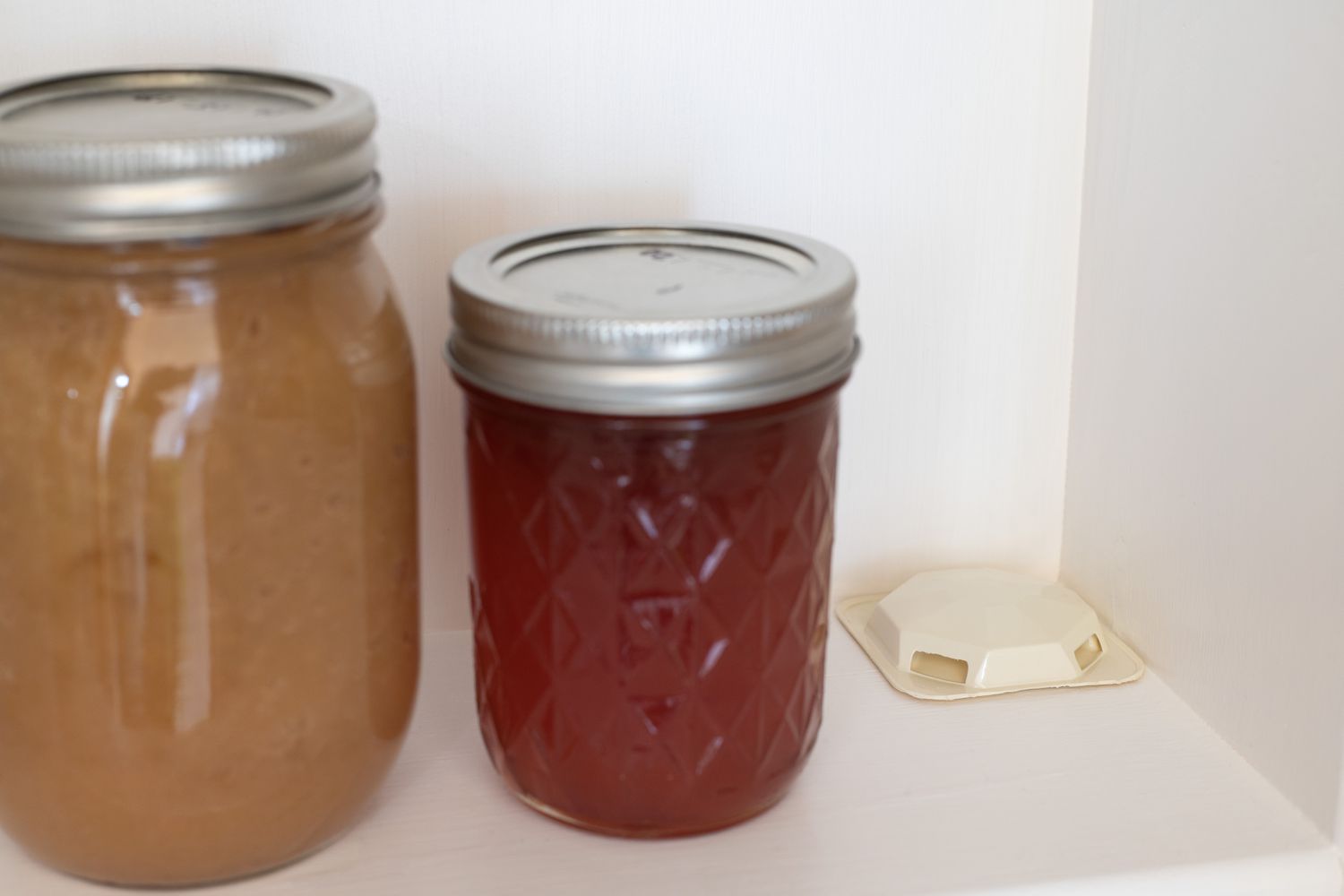 Ameisenköderpackung in der Ecke des Regals neben Glasbehältern mit Marmelade