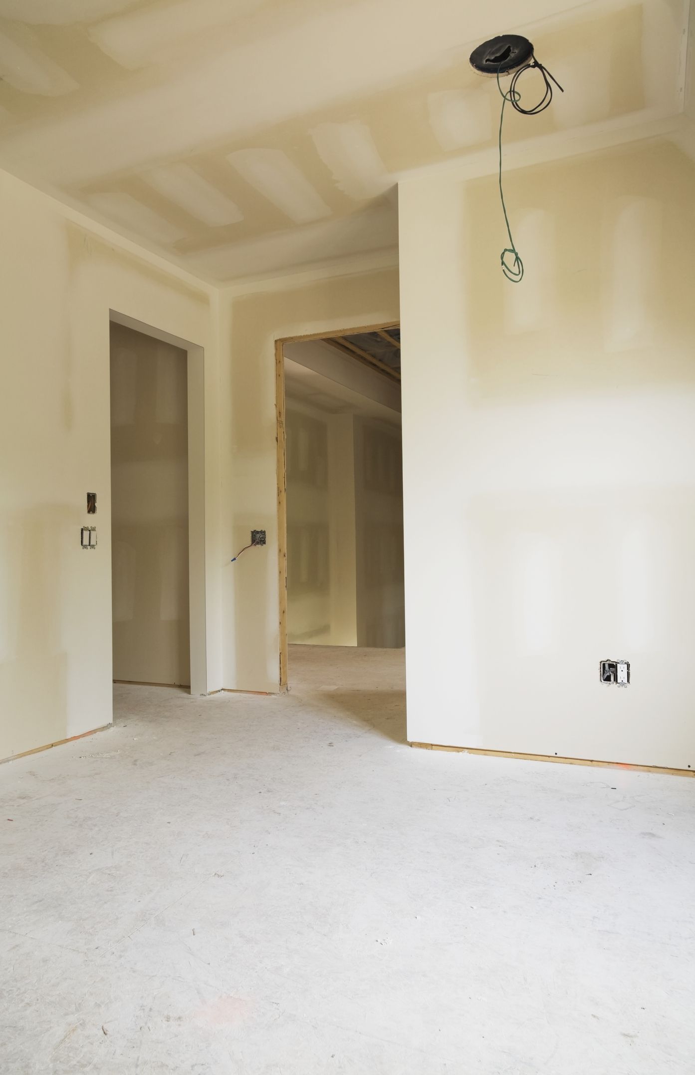 An unfinished room with hung drywall
