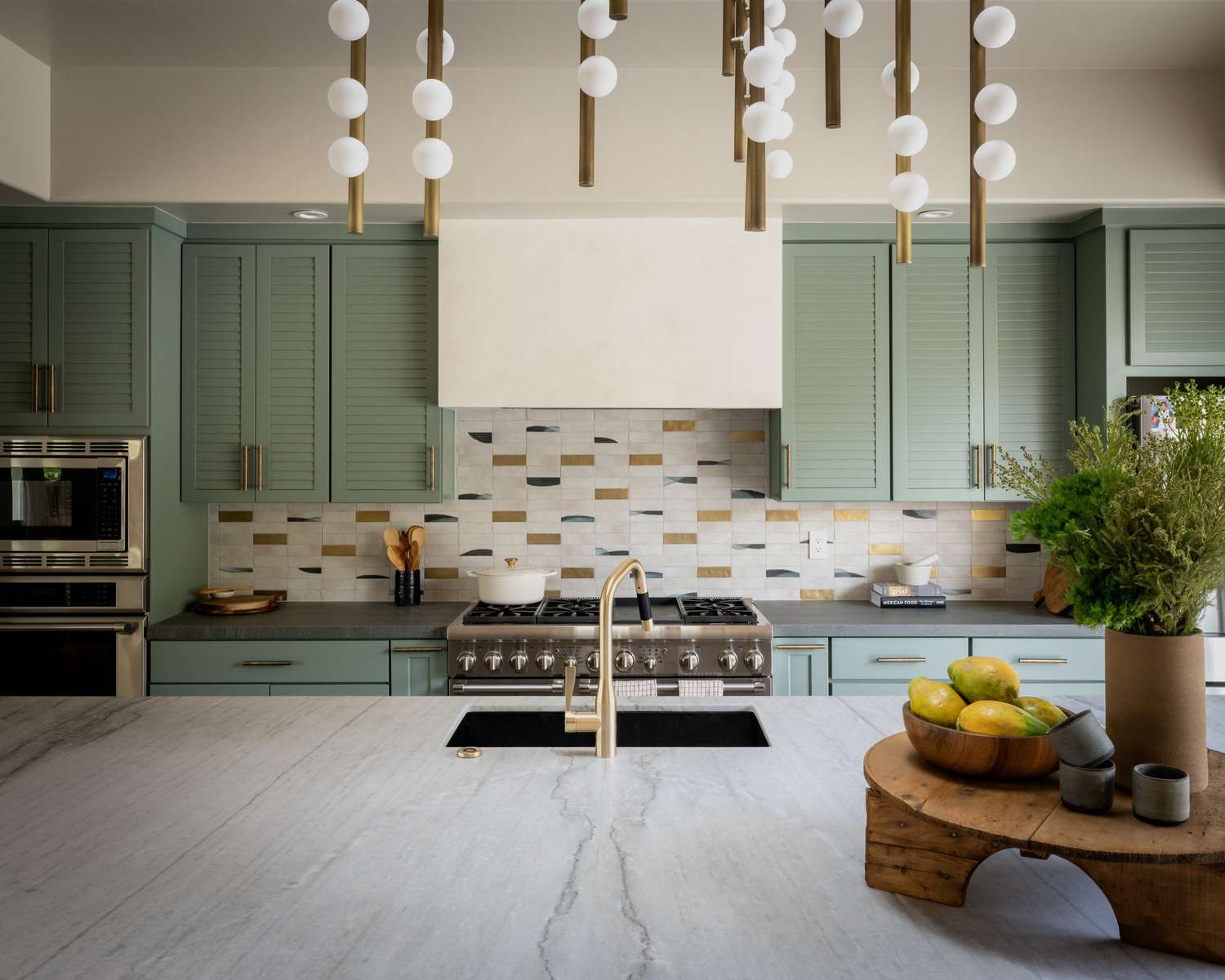 modern white kitchen with seafoam green cabinets and unique backsplash