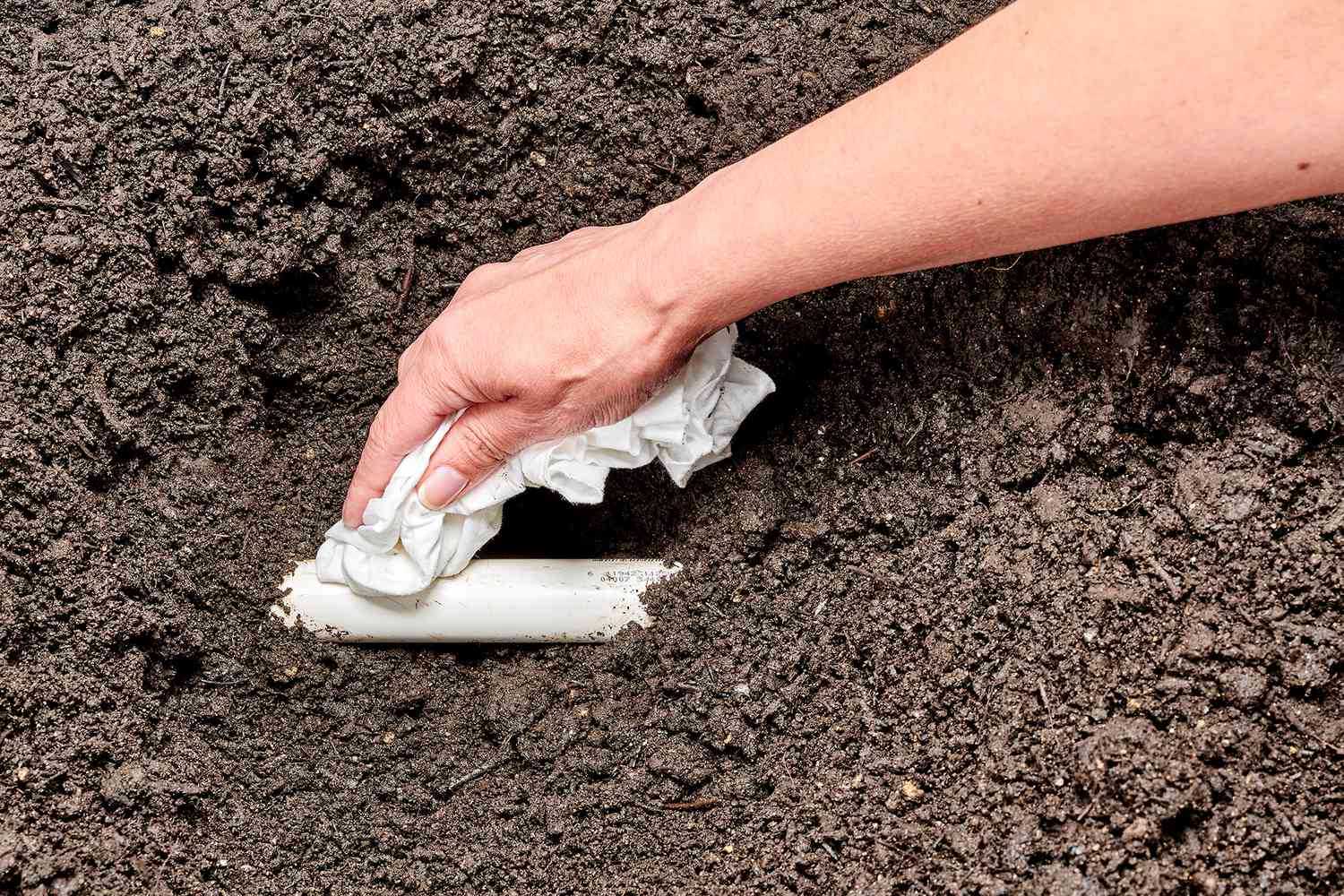 PVC pipe in ground wiped clean with paper towel