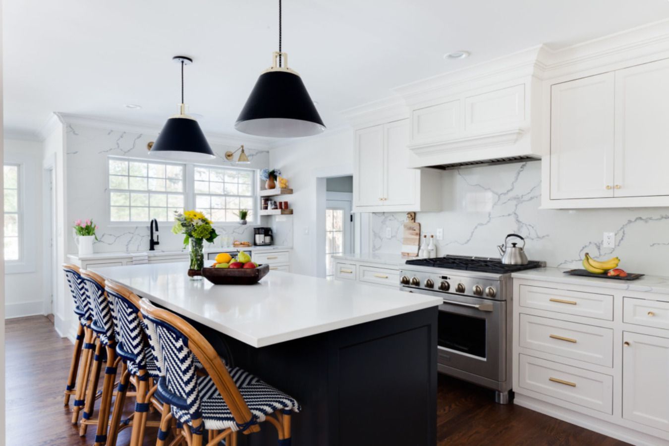 Cuisine en marbre et quartz avec chaises bleues et blanches.