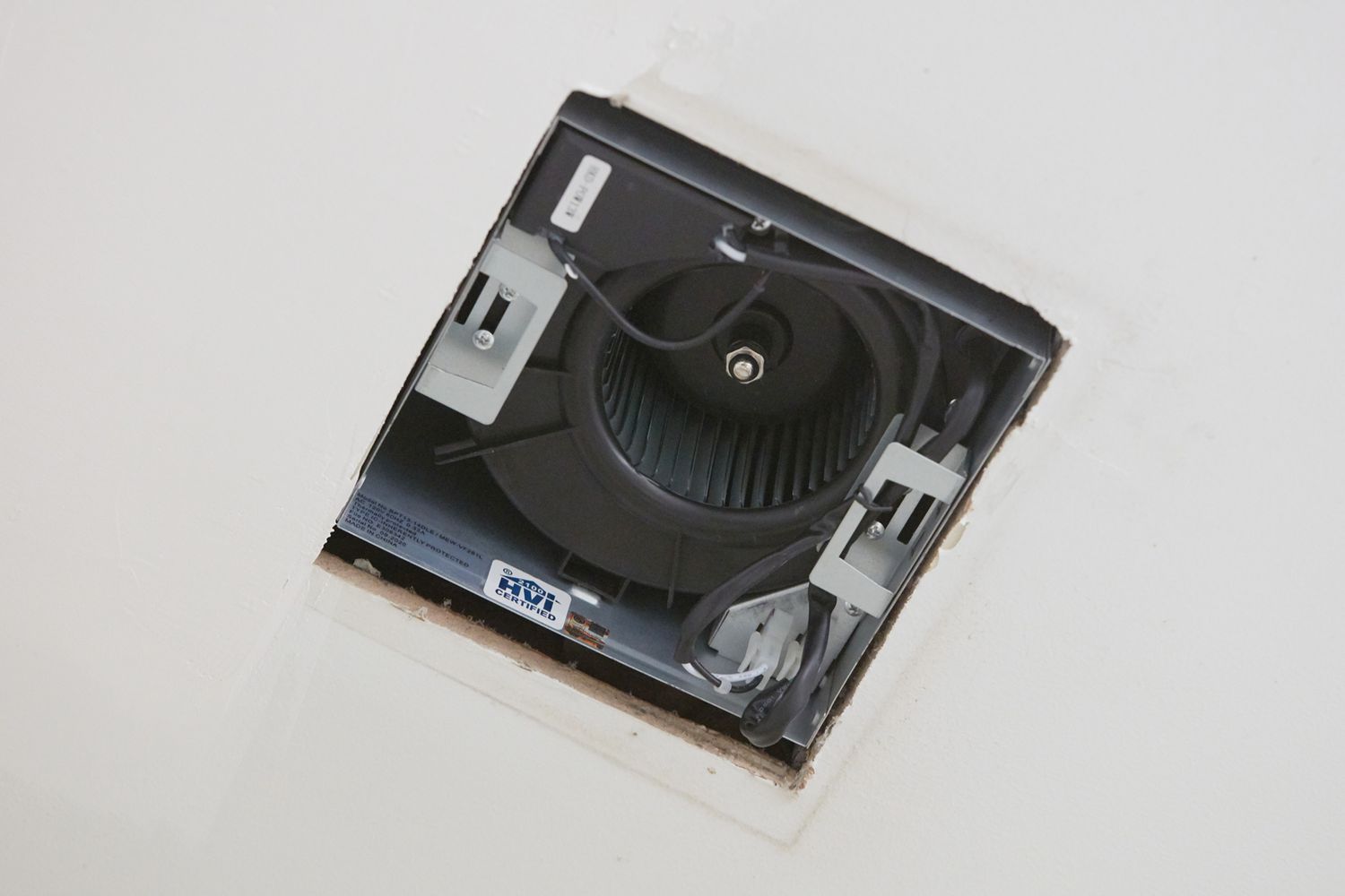 Ventilateur d'extraction de salle de bains exposé dans le trou du plafond