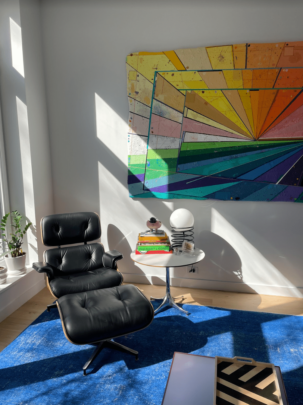 Wohnzimmer mit eleganter Kunst und hellblauem Teppich.