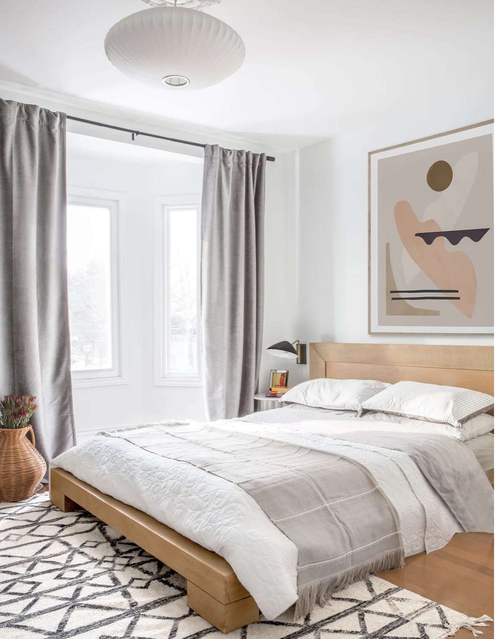 dormitorio con alfombra estampada y obra de arte abstracta en la pared