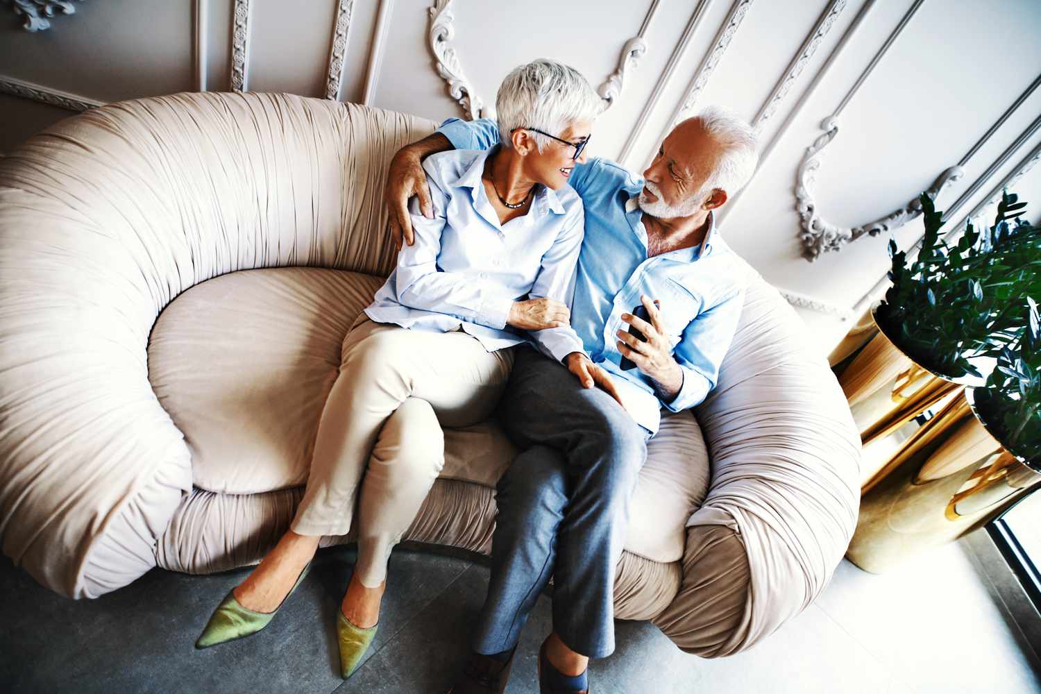 Älteres Paar sitzt und spricht auf einem Sofa