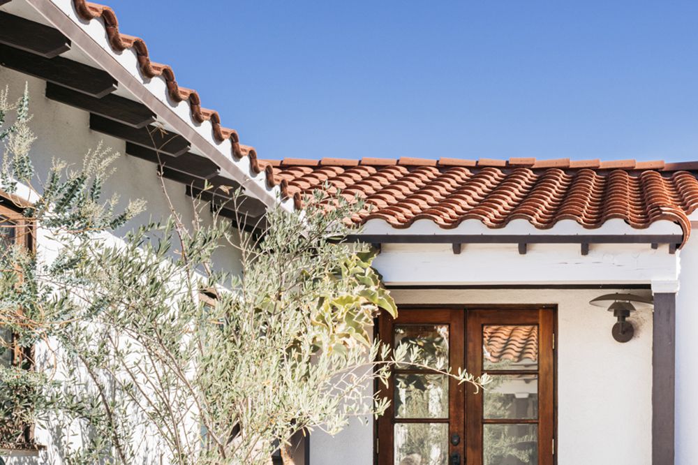 Braune spanische Dachziegel auf dem Dach eines weißen Hauses