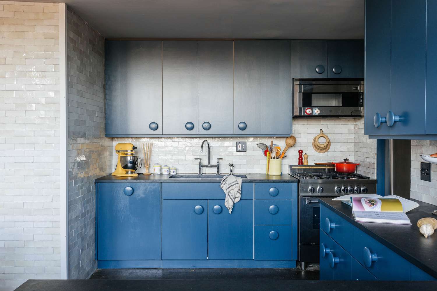 Armários de cozinha em azul profundo com puxadores grandes e redondos