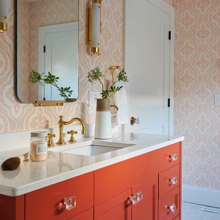 Salle de bain avec papier peint orange et meuble-lavabo 