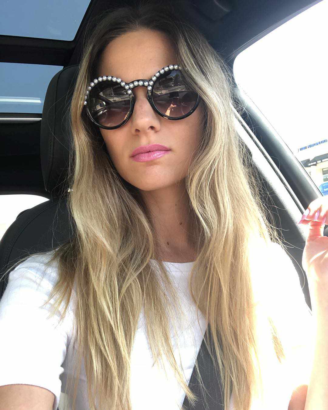 Frau mit Sonnenbrille in einem Auto sitzend