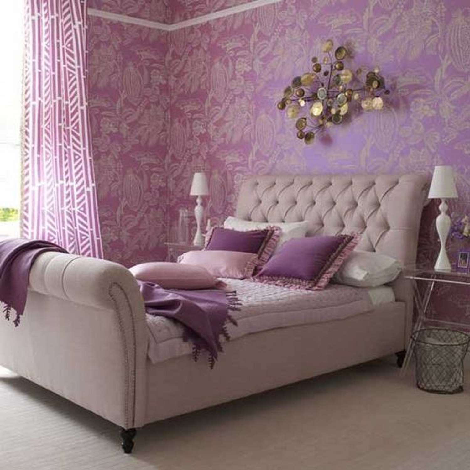Lavendelfarbenes Schlafzimmer mit gemusterter Tapete, metallischen Akzenten und gepolstertem Bett