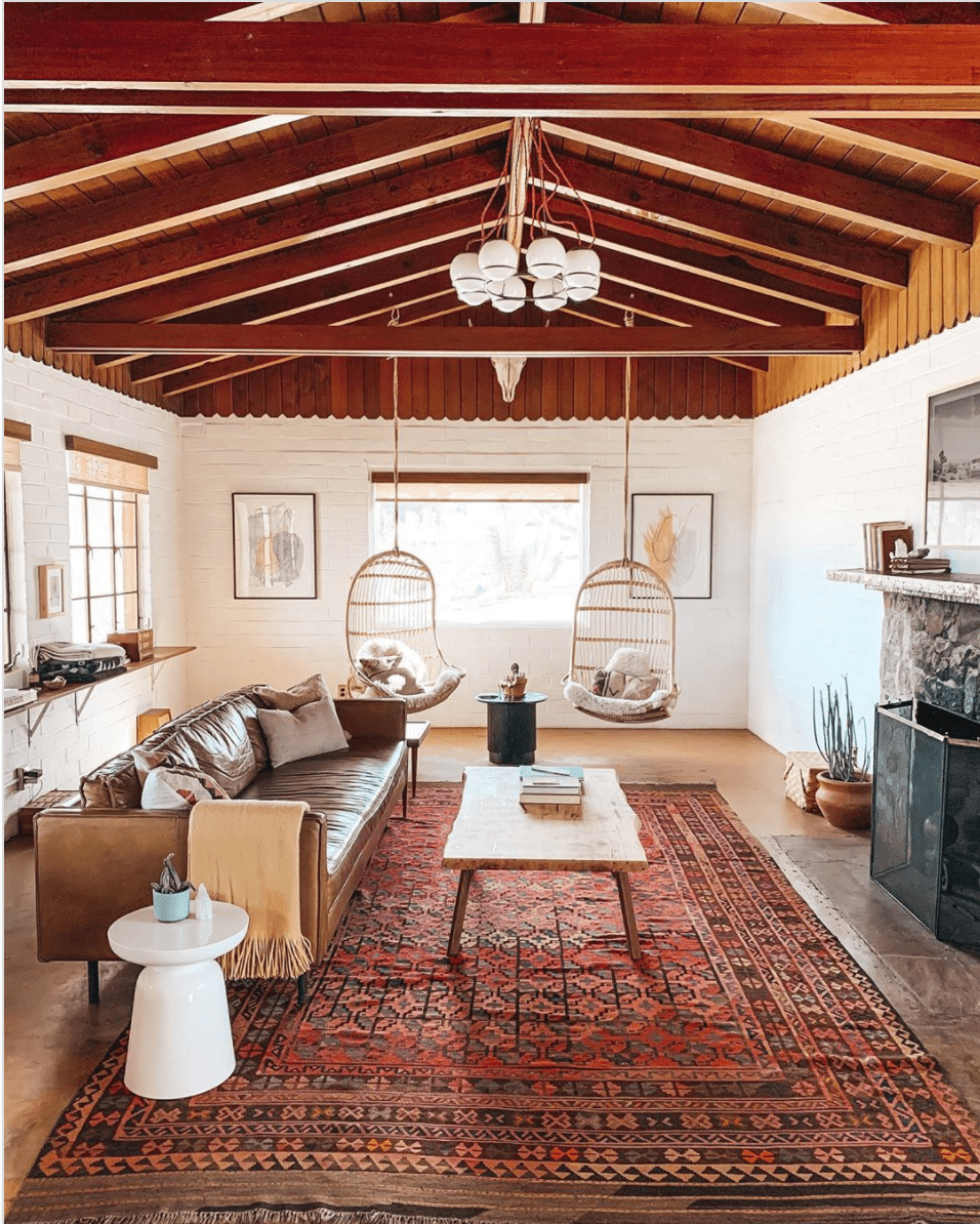 Uma sala de estar em estilo do sudoeste com vigas de madeira no teto.