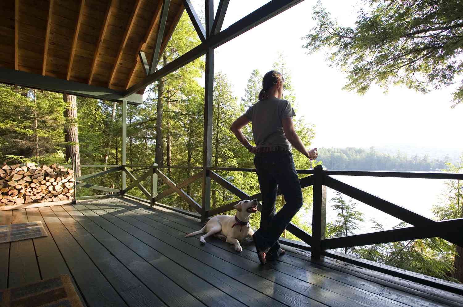 Frau auf Blockhausdeck am See