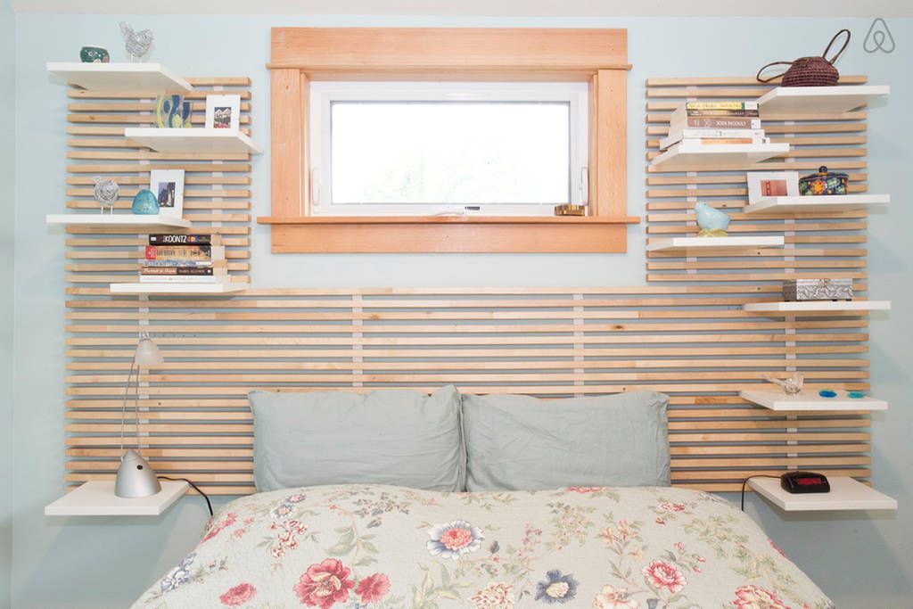 prateleiras de ripas de madeira acima da cama com janela retangular
