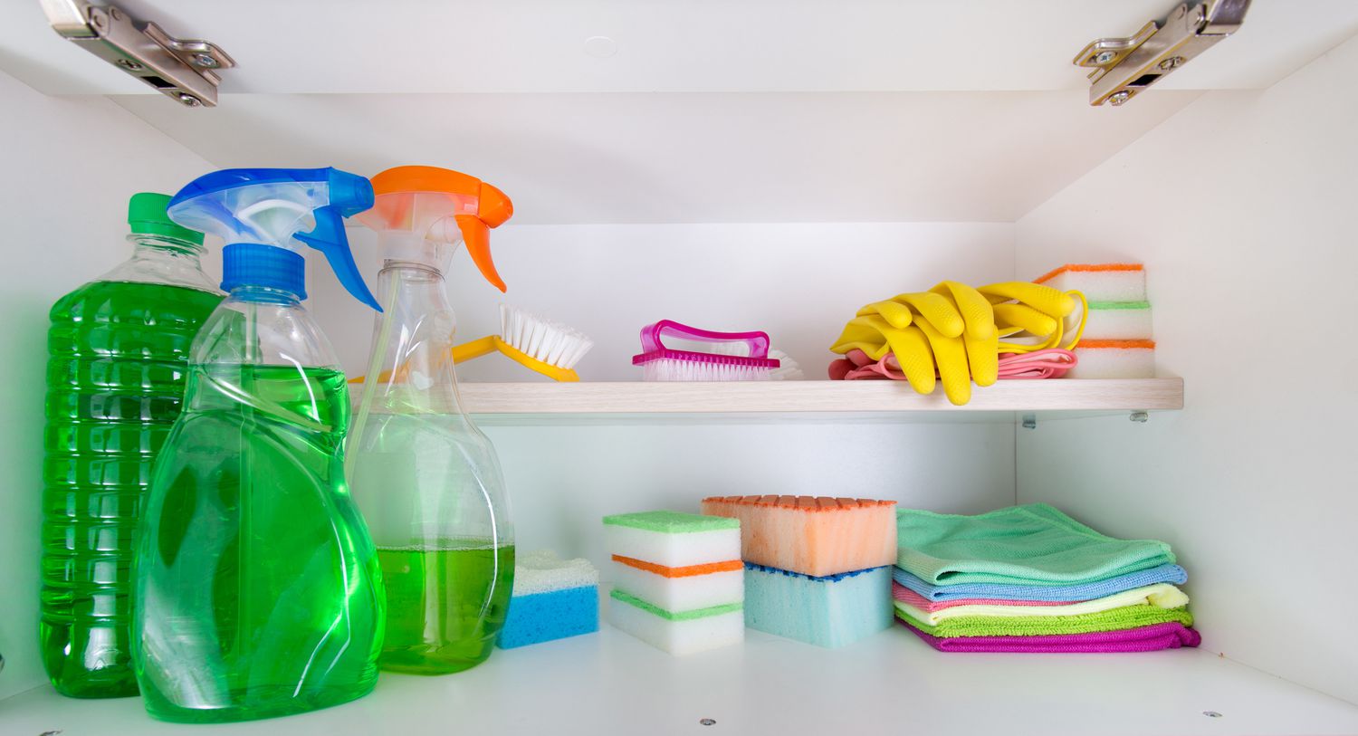 Cleaning supplies in a white cabinet.