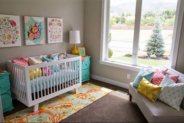 Cuarto de niños neutro con colorido verde azulado, amarillo y acentos florales.