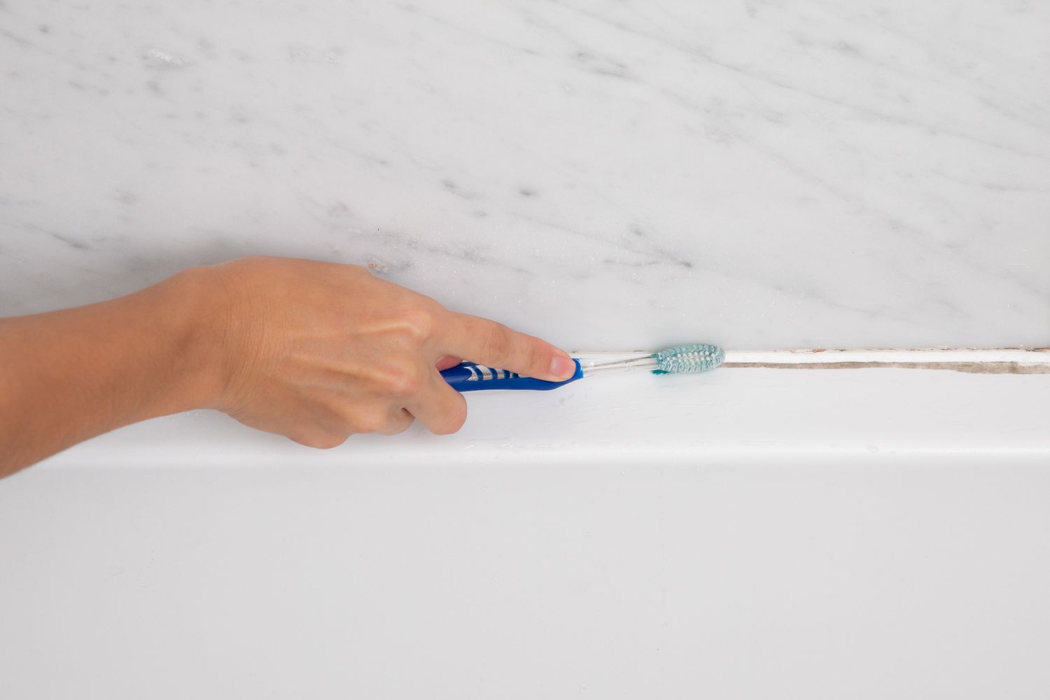 limpando o rejunte com uma escova de dentes