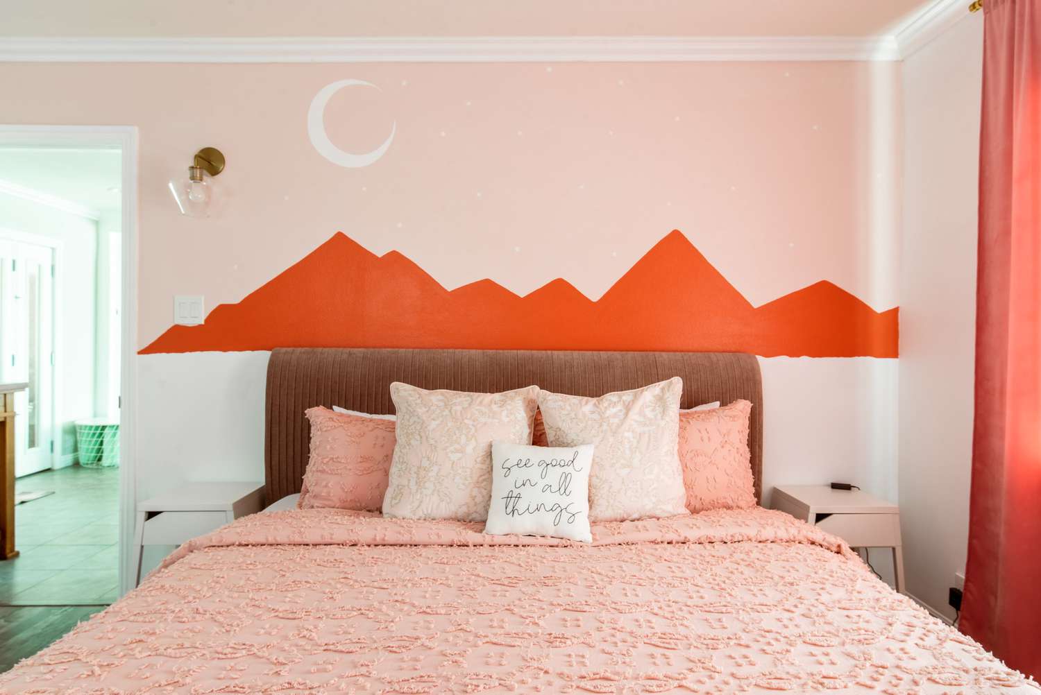 Rosa Schlafzimmer mit Bett in rosa und weißer Bettwäsche und gemalter Berglandschaft an der Wand