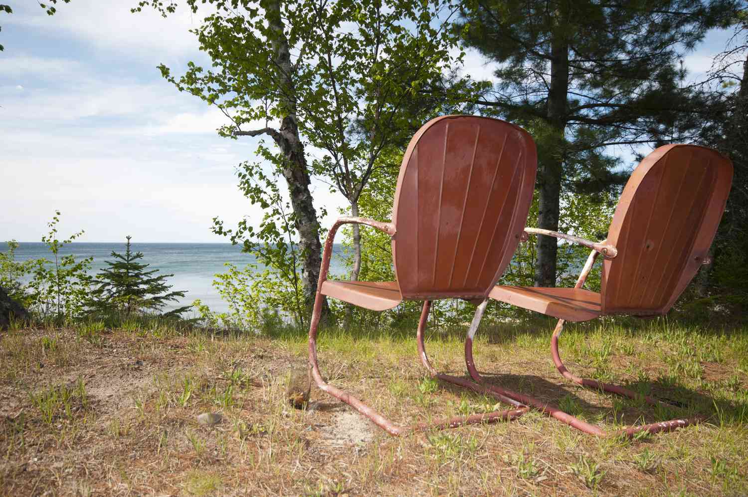 retro orange lawn chairs looking out over a lake