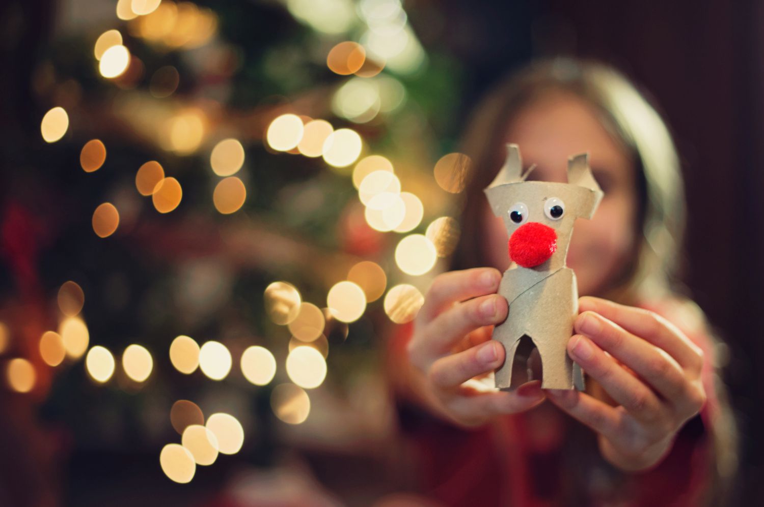 Rudolf. Um enfeite de Natal feito à mão na mão de uma garota