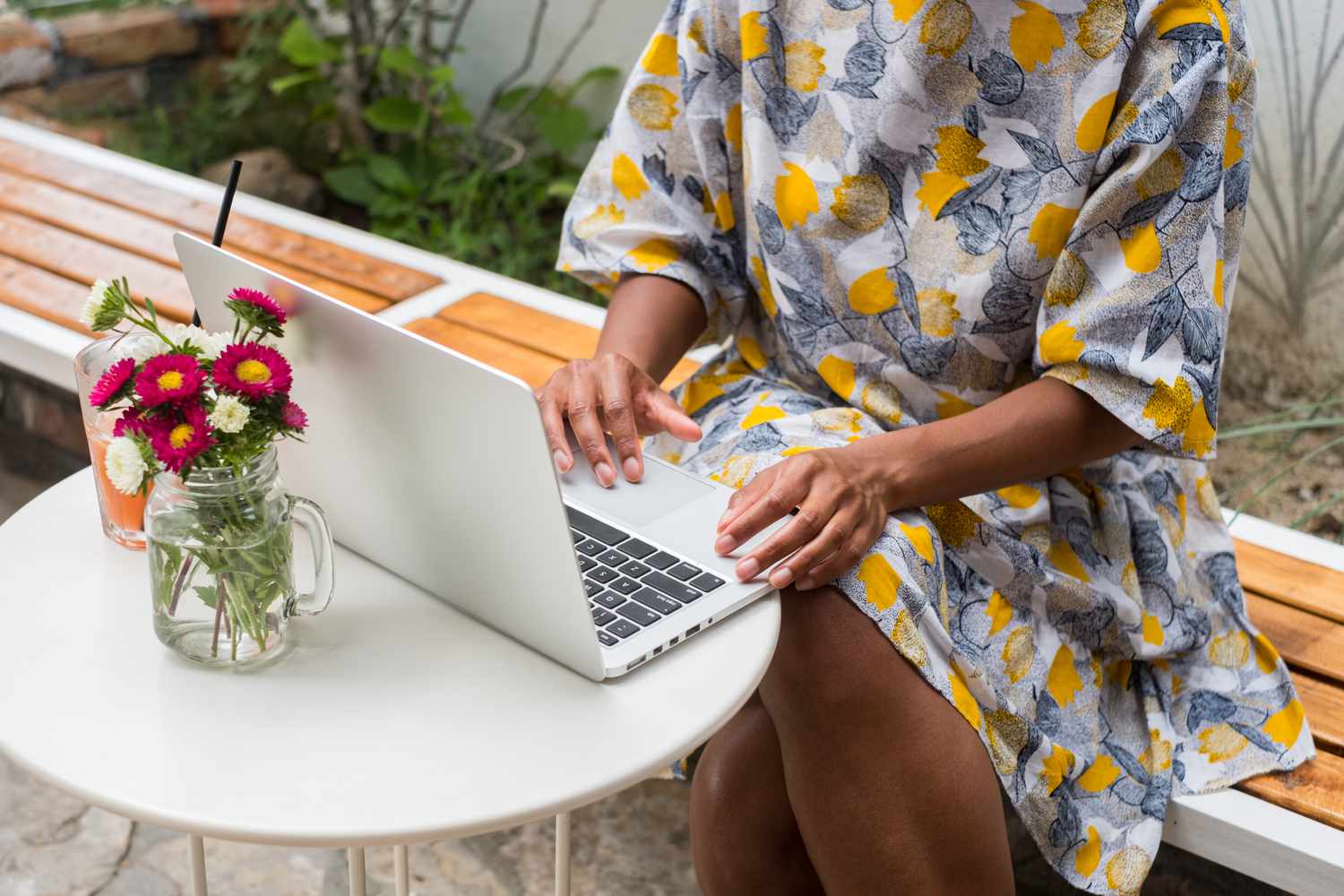 Frau arbeitet im Freien an einem Laptop