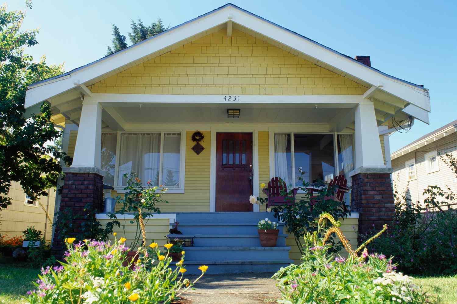 Un jardin coloré a inspiré la couleur de peinture pour ce joyeux bungalow jaune