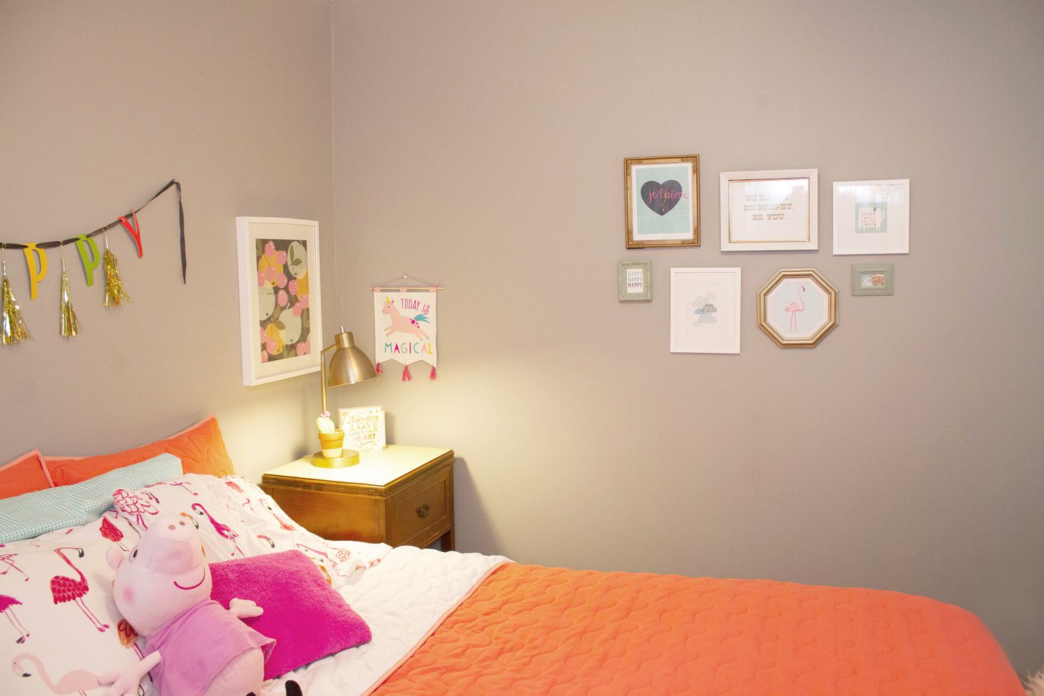 Pequeñas obras de arte en marcos de diversas formas colgadas en la pared del dormitorio
