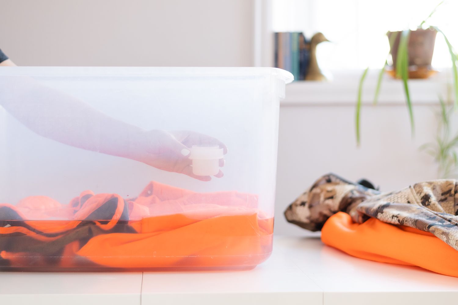 Laundry detergent being poured on hunting clothes