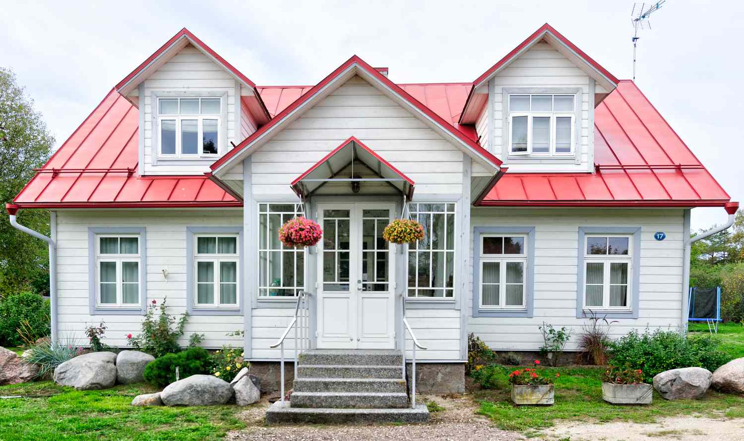 Petite maison avec toit rouge et jolie porte d'entrée