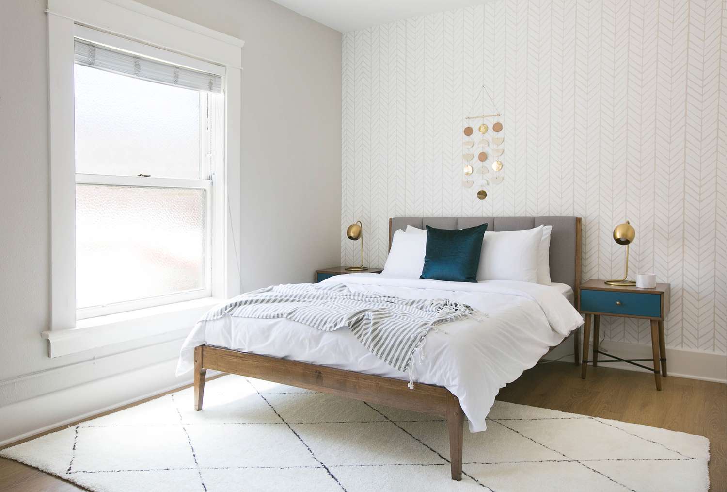 Chambre à coucher grise et blanche avec une touche de couleur aqua. La chambre suit la règle des couleurs 60-30-10