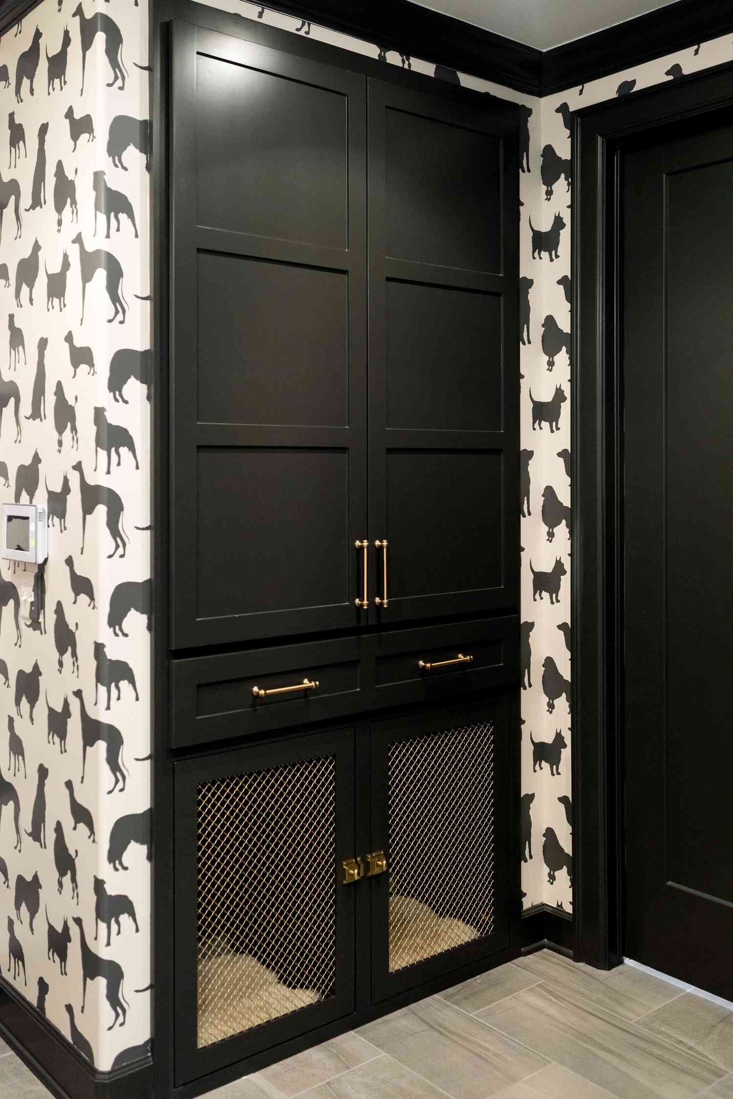 Un mudroom con zona para mascotas y papel pintado en blanco y negro con motivos de perros.