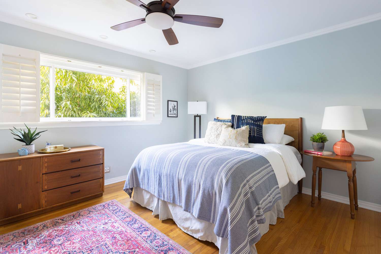 Schlafzimmer mit hellblauen Wänden und natürlichem Licht, das durch das Fenster einfällt