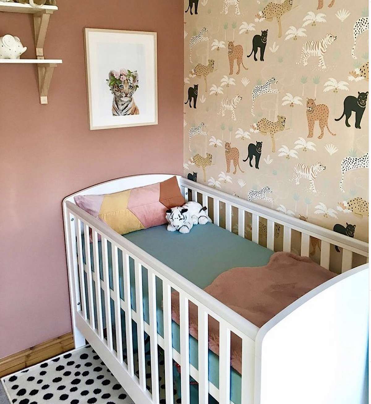 habitación infantil temática selva con pared melocotón y cuna blanca