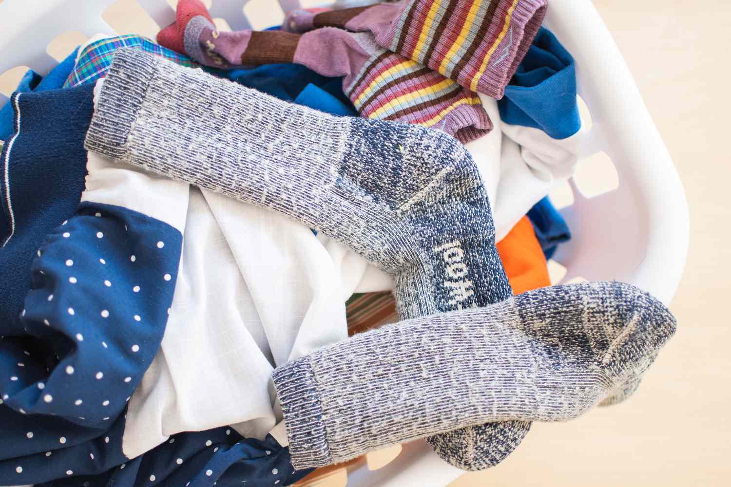 Superwash Wollsocken in einem Wäschekorb voller Kleidung