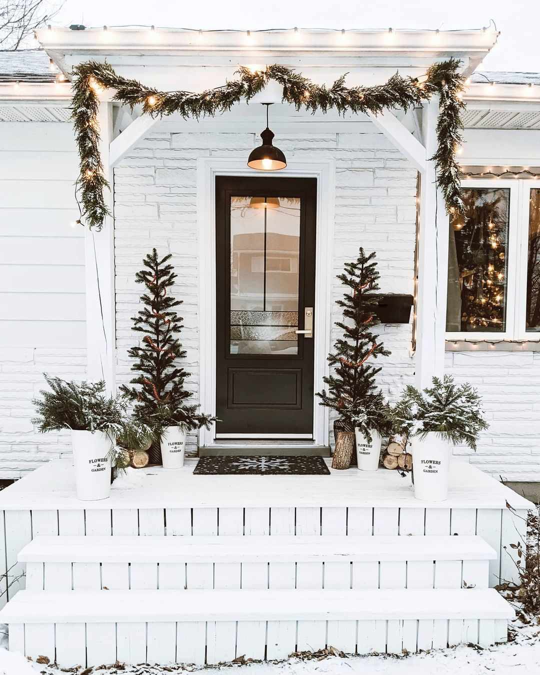 Eine weiße, mit Weihnachtsgrün geschmückte Hausfassade.