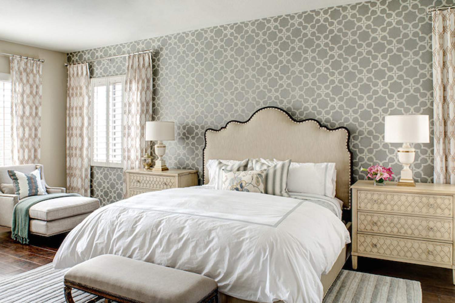Schlafzimmer mit Tapeten, Vorhängen und Nachttischen in komplementären Mustern