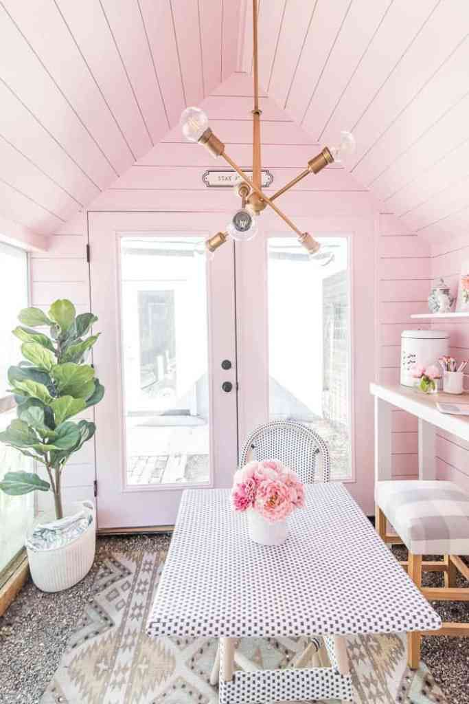 Ein rosa Innenraum mit einem Kronleuchter.