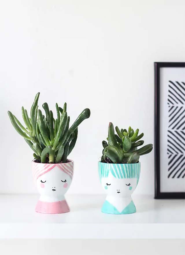Two succulent pots with painted faces on them