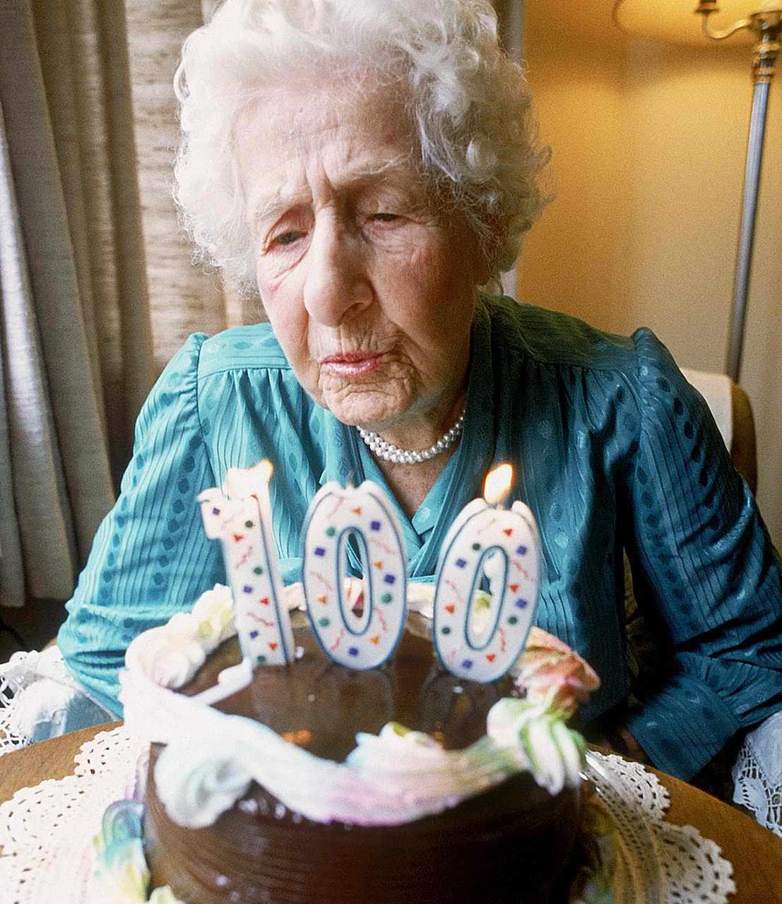 Alte Frau bläst Kerzen aus