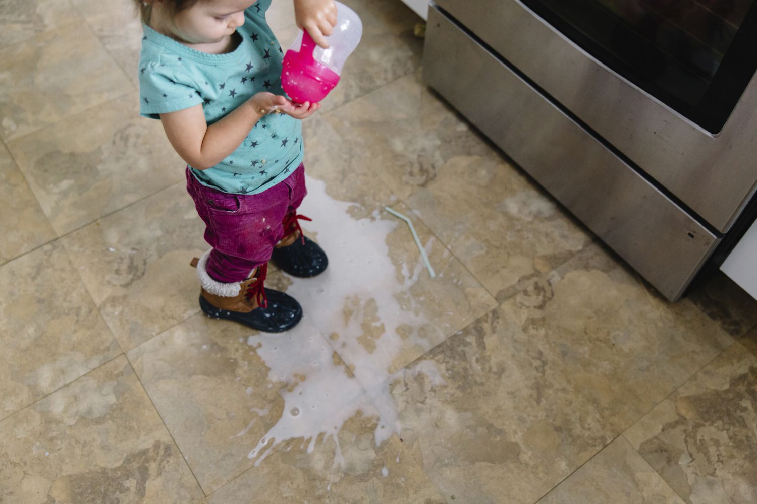 Junges Mädchen mit verschütteter Milch in der Küche