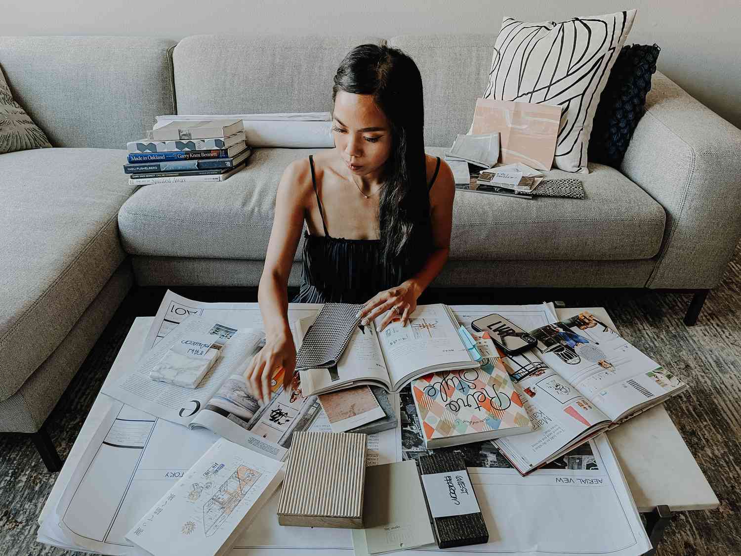 Lauren Reyes Lim posa con libros y revistas junto a un sofá