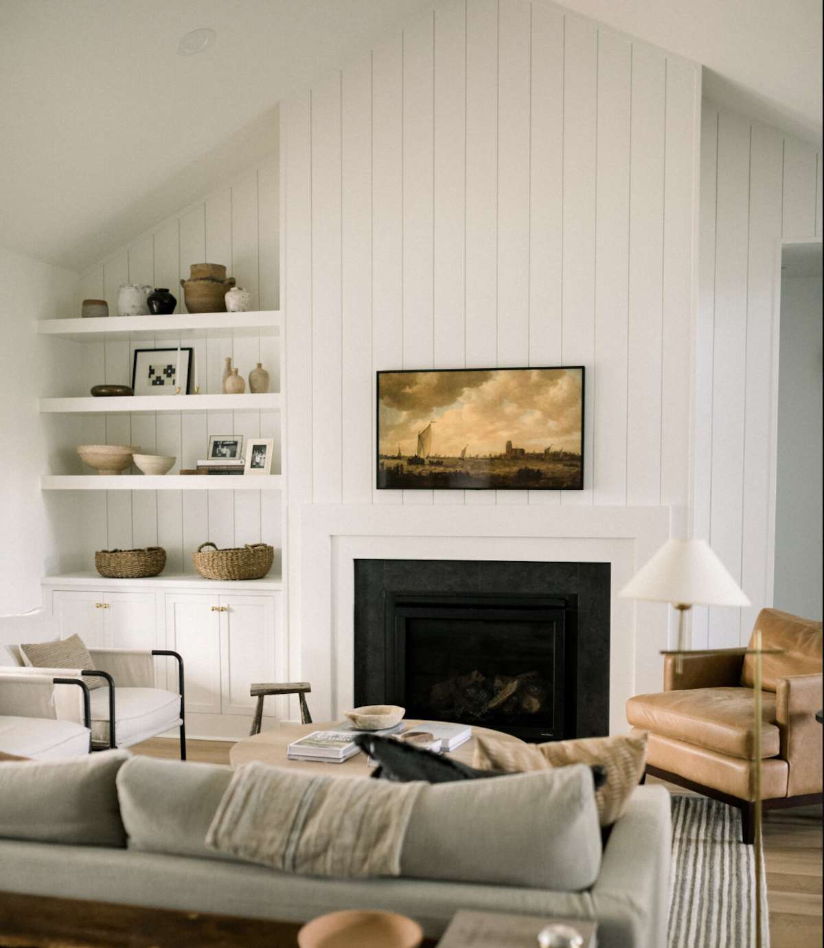 black tile fireplace with white mantle and shiplap wall
