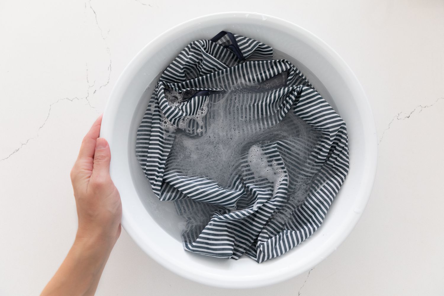 Nylon reusable bag being washed by hand in soapy water
