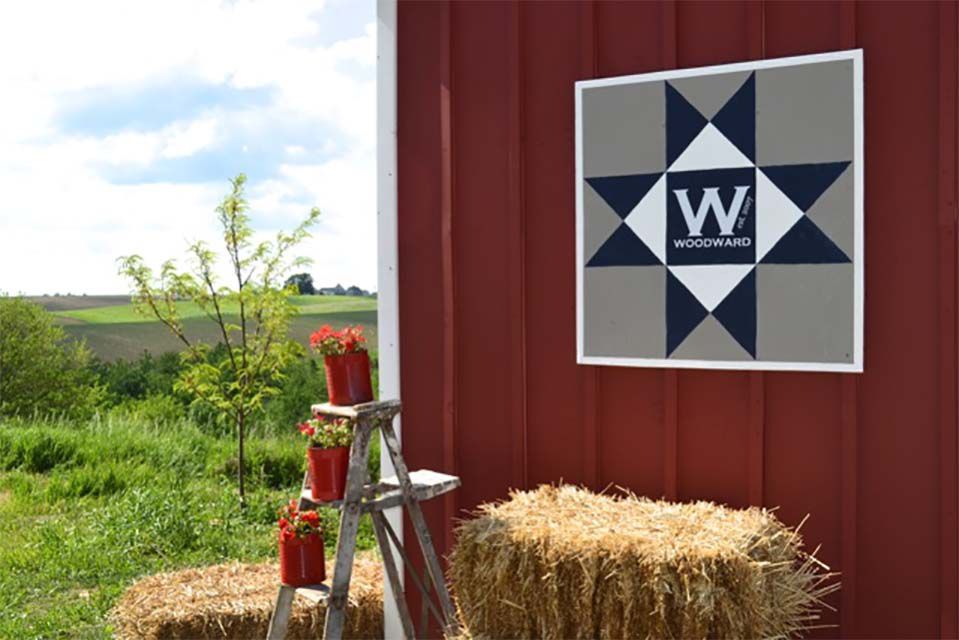 A gray and blue barn quilt on a barn